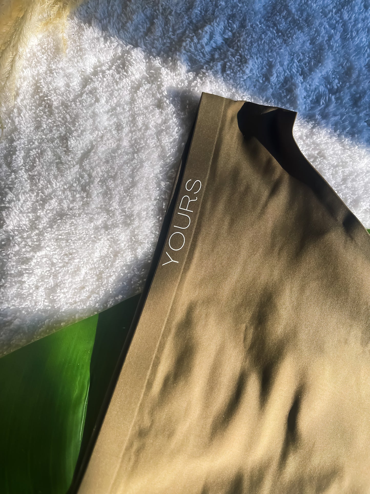 Olive-colored Clean Brief on White carpet, logo closeup