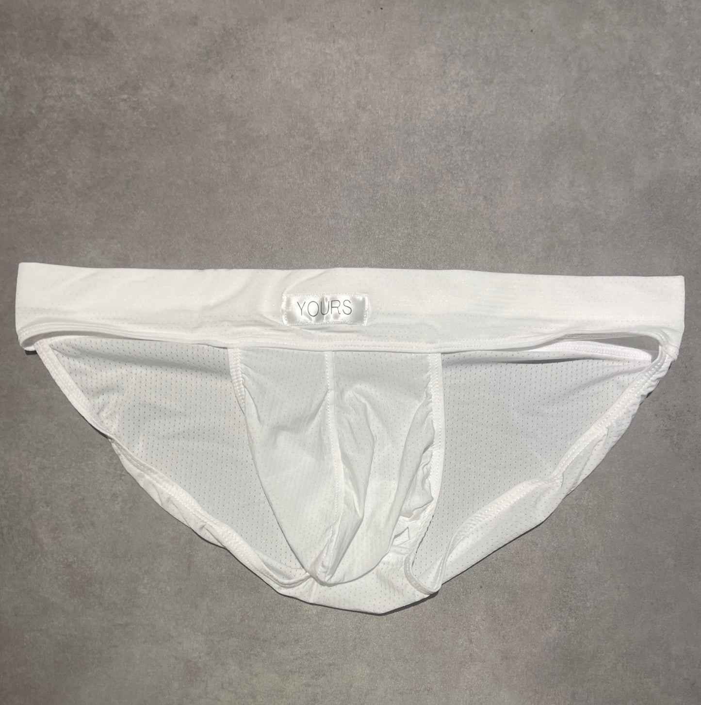 Flat lay photo of white striped briefs