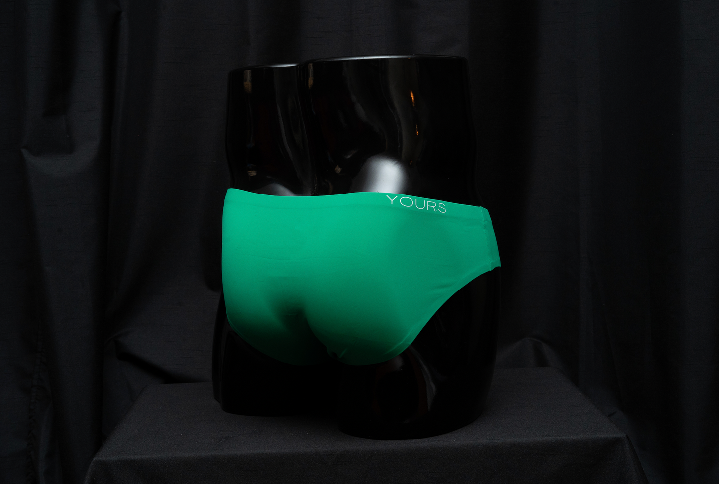 Emerald-colored clean brief, backside on mannequin